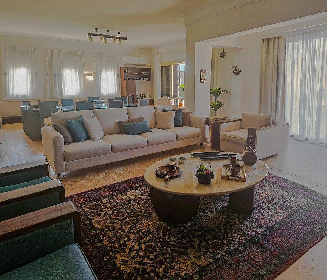 Photographed living and dining room with tailored seating and a marble table